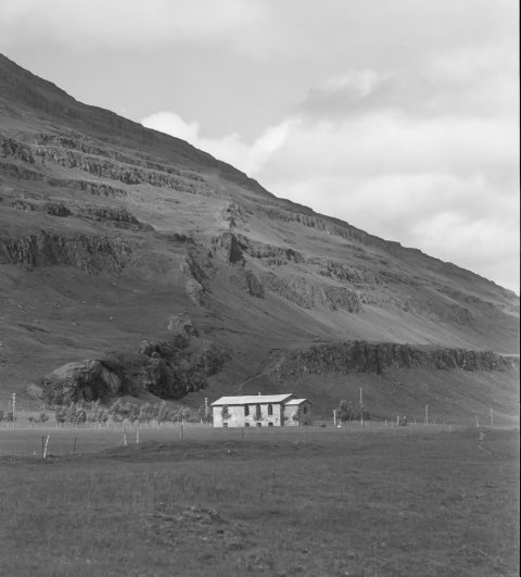 Ólafur Jónsson, ráðunautur og rithöfundur,  tók þessa mynd í Fljótsdal á Héraði, við kirkjustaðinn Valþjófsstað. Berggangurinn sem skásker Valþjófsstaðafjall kallast Tröllkonustígur og er mjög áberandi. Húsið á myndinni, Ungmennafélagshúsið, var byggt á árunum 1912 til 1917 af Ungmennafélagi Fljótsdæla og varð miðstöð alls félagsstarfs í sveitinni, skv. Fljótsdælu, bók Helga Hallgrímssonar náttúrufræðings um mannlíf og náttúrufar í Fljótsdalshreppi. Húsið var síðar rifið og nýtt byggt á sama stað um 1960. Það heitir Végarður er nú samkomuhús sveitarinnar.