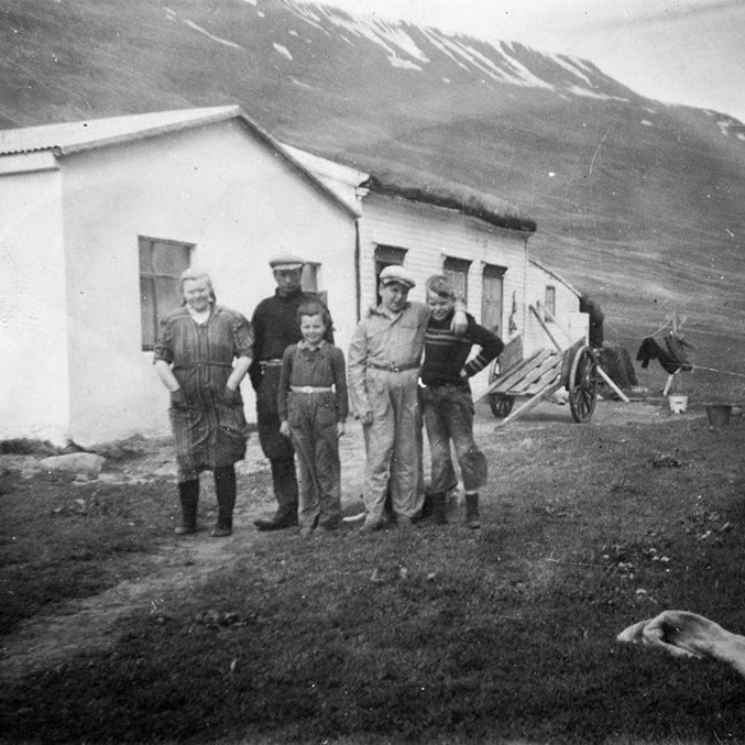 Þetta er bærinn Gullbrekka í Saurbæjarhreppi hinum forna. Lilja Sverrisdóttir skrifar: Afi minn og amma keyptu jörðina 1943 og byggðu þennan nýja hluta sem er á myndinni, ári seinna. Árið 1954 byggðu þau svo við þennan nýja hluta og rifu gamla bæinn. Í leiðinni snéru þau þakinu á syðri hlutanum svo stafninn snéri þá í suður en ekki austur eins og er á myndinni. Fyrir framan húsið standa frá vinstri hjónin Lára Jóhannesdóttir og Magnús Tryggvason, drengurinn fyrir framan held ég að sé Björn Heiðar Garðarsson frá Gilsá, systursonur Láru, næst er Haukur J. Magnússon yngri sonur þeirra og lengst til hægri er Hrafn Gíslason Johnsen, systursonur Magnúsar frá Vestmannaeyjum. Þetta er tekið í kringum 1950.