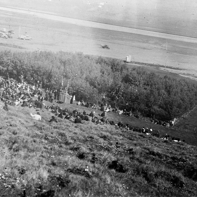 Þetta mun vera Aldísarlundur á Hrafnagili. Syðra-Laugaland handan árinnar. Lundurinn er kenndur við Aldísi Einarsdóttur á Stokkahlöðum sem var mikil ræktunarkona og hafði forgöngu um plöntun í lundinum. Í dag er þessi skógur gróinn saman við seinni tíma trjárækt í brekkunum ofan við Hrafnagil, skv. upplýsingum frá lesanda. Ábending barst um að sennilega sé myndin tekin á 50 ára afmæli KEA árið 1936. - m-stae1-15379 frá Minjasafninu á Akureyri