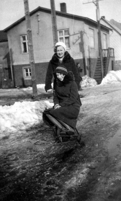 17 – Lesandi sendi eftirfarandi: Myndin er tekin á horni Glerárgötu og Gránufélagsgötu á Akureyri, horft er austur Gránufélagsgötu yfir Glerárgötu. Stúlkan sem situr sparksleðann er Anna Sigríður Eggertsdóttir Guðmundar byggingameistara frá Siglunesi sem byggði Gránufélagsgötu 11 og bjó þar ásamt Stefaníu Sigurðardóttur frá Kambhóli og 9 börnum. Stúlkan sem stendur er Hlín Jónsdóttir  Jónatanssonar járnsmiðs sem bjó í Glerárgötu 3 ásamt konu sinni Þórunni Friðjónssyni frá Sandi. Anna var fædd 1910 og Hlín 1911 og voru þær vinkonur og nábúar. Tvö húsin sem er nær eru farin í dag og húsið sem er næst var kallað Guðmundarhús en þar átti heima Guðmundur og fjölskylda, einn sonur þeirra er Jón Oddgeir Guðmundsson sem í dag býr í og á Glerárgötu 1. Hann á líka „Litlu búðina“ sem er þar í bakhúsi og selur hann þar t.d. bílabænina. Næsta hús þarna var kallað Strýta og Ferðafélagið fékk það hús og flutti að ég held inn í Herðubreiðalindir og er þetta hús skáli þar í dag. Húsið sem sér aðeins í gaflinn á er Gránufélagsgata 19. -  Minjasafnið á Akureyri / Mynd 080-030