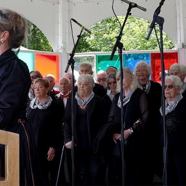 17. júní 2024 – Halla Björk Reynisdóttir, forseti bæjarstjórnar, flutti ávarp á samkomunni í Lystigarðinum. Að baki hennar er kór eldri borgara, Í fínu formi, sem söng undir stjórn Petru Bjarkar Pálsdóttur.