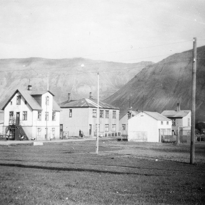 Ekki stóð á svörum við þeirri spurningu hvar þessi mynd væri tekin. Sverrir Páll Erlendsson sendi til dæmis eftirfarandi upplýsingar: 
Þetta er á Siglufirði við norðurenda gamla fótboltavallarins, sem nú er verið að byggja á. Til hægri sést í hús sem merkt er BÍÓ. Þetta er Alþýðuhúsið þar sem Aðalheiður Eysteinsdóttir hefur nú aðsetur og vinnustofu.

Litla húsið með dökku þaki nær okkur er löngu farið og líka næstu tvö hús, það hvíta var áhaldahús fyrir völlinn en hitt var hornhús á mörkum Túngötu, sem liggur eftir endilöngu frá norðri til suðurs, frá Torginu norður í Hvanneyrarkrók. Hornhúsið var íbúðarhús en löngu farið.

Hin gatan er Þormóðsgata sem liggur upp brekku, sem ekki sést. Háreista húsið með kvistinum er Sölvahúsið, og því miður löngu búið að rífa það. Hitt húsið, tveggja hæða með gluggaröðinni út að Þormóðsgötu er Hólakot, timburhús sem stendur enn, mjög ryðgað og því miður illa útlítandi utan frá. Þar eru að mig minnir 3 eða 4 íbúðir.

Hinum megin við túngötuna, norðan við Alþyðuhúsið, er myndarlegt hús sem stendur enn.

Þetta er gömul mynd því ef hún væri yngri sæist á bak við Sölvahús og Hólakot hin mikla Mjölskemma Síldarverksmiðja ríkisins, sem var kölluð Ákavíti og var stærsta bygging á Íslandi að flatarmáli áður en ameríski herinn byggði flugskýli á Keflavíkurvelli sem var stærra. Mjölskemman var reist 1946, stálgrindarhús með tveim burstum eftir endilöngu. Snjórinn veturinn eftir var nógur til að þakið hrundi og var gert upp á nýtt 1947 og þá bara ein burst. Stendur enn.

Sem sagt húsin á gatnamótum Túngötu og Þormóðsgötu á Siglufirði. - / m-stae1-15589 frá Minjasafninu á Akureyri