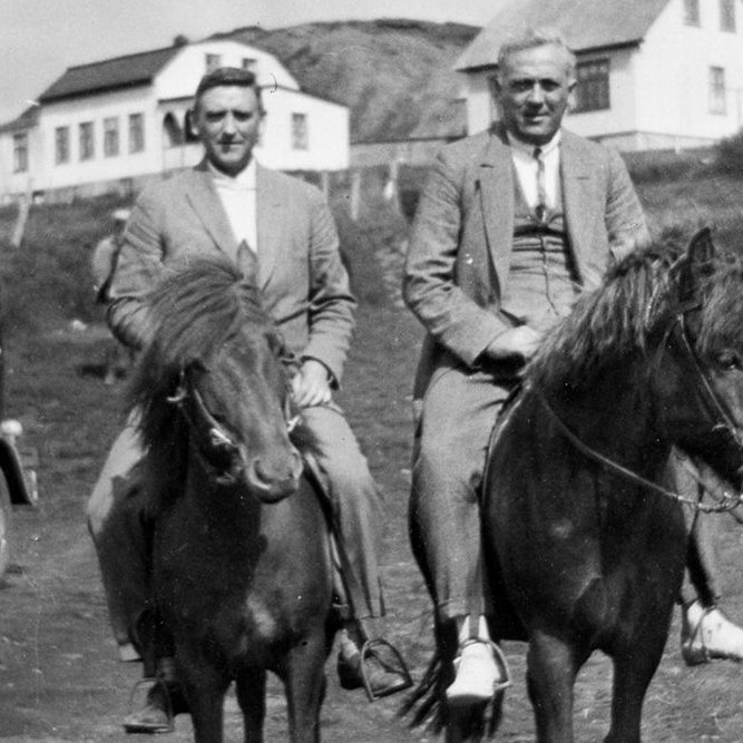 Þetta er bærinn Stórólfshvoll í Hvolhreppi. Staðfest er að maðurinn vinstra megin er Sigtryggur Eiríksson, öðru nafni Tryggvi Kaldan, sem bjó og starfaði sem læknir í Helsingjaeyri í Danmörku. Hugsanlegt er að maðurinn til hægri sé ljósmyndarinn Willem van de Poll sem ferðaðist um landið árið 1934. Einn lesandi sagði mögulegt að bíllinn á myndinni sé sá sem notaður var í því ferðalagi, R-765. Annar lesandi benti á að maðurinn til hægri gæti verið Helgi Jónasson ((1894–1960) læknir á Stórólfshvoli 1925–1955) og alþingismaður Rangæinga 1937–1956). Vonandi fæst úr því skorið.  - / m-stae1-15690 frá Minjasafninu á Akureyri