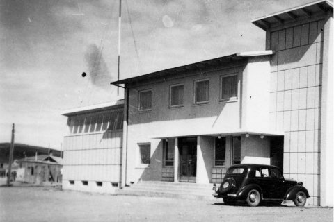 Þetta er Garðarsbraut 21 á Húsavík. Elín Björg Ragnarsdóttir skrifaði eftir að myndinni var deilt á Facebook síðunni Gamlar ljósmyndir: „Þetta er gamla heimilið mitt Póstur og sími Húsavík. Pabbi var stöðvarstjóri þarna frá 1962-1987 og var íbúð á efri hæðinni fyrir fjölskyldu stöðvarstjóra líkt og var víða um land á þessum árum. Koparþak var sett á lægri bygginguna vegna leka fljótlega eftir að pabbi kom norður þannig að gluggaröndin efst er ekki lengur til staðar heldur koparfrontur. Upp úr 1980 var byggt við húsið og hýsir sá hluti nú Vínbúðina en gistiheimili er í þeim hluta sem er á tveimur hæðum. Síminn er svo með restina af húsinu í dag.“ / m-stae1-16119 frá Minjasafninu á Akureyri