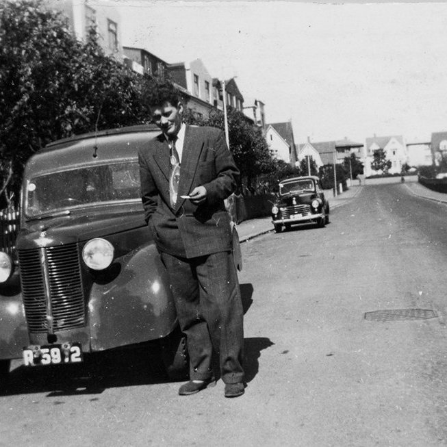 Hér er horft norður Ljósvallagötu í Reykjavík, kirkjugarðurinn við Suðurgötu, Hólavallagarður, er handan girðingarinnar hægra megin á myndinni. Hús við Sólvallagötu og Hólatorg í fjarska. Ekki hefur tekist að bera kennsl á manninn. / m-stae1-16126 frá Minjasafninu á Akureyri