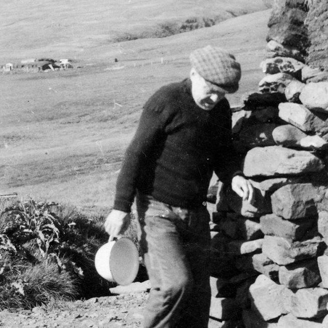 Þetta er Jóhannes Frímannsson (1880-1963) bóndi á Gilsá í Eyjafirði. Þarna er hann að tæma næturgagnið, koppinn sinn, væntanlega fyrir utan torfbæinn á Gilsá. - / m-stae1-15958 frá Minjasafninu á Akureyri