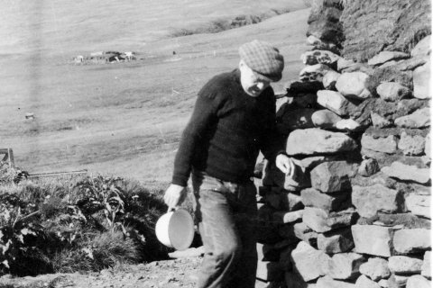 Þetta er Jóhannes Frímannsson (1880-1963) bóndi á Gilsá í Eyjafirði. Þarna er hann að tæma næturgagnið, koppinn sinn, væntanlega fyrir utan torfbæinn á Gilsá. - / m-stae1-15958 frá Minjasafninu á Akureyri