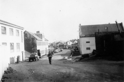 Þetta er í Vestmanneyjum. Myndin er tekin austur Strandveg, fremstu húsin bæði vinsta og hægra megin eru svokölluð Sælahús, skv. upplýsingum sem bárust. Annað húsið vinstra megin, það reisulega með kvistinum, er Magnahúsið sem svo er kallað – þar var Vélsmiðjan Magni með starfsemi en í húsinu nú rekið veitingahúsið Slippurinn. - / m-stae1-16289 frá Minjasafninu á Akureyri