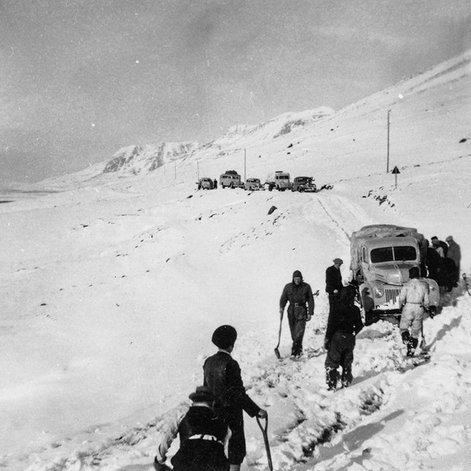 Eftir nokkur röng gisk áttuðu margir sig á því hvar myndin er tekin. Gísli Sigurgeirsson, fyrrverandi fréttamaður á Akureyri, skrifaði til dæmis: Já, þetta er í Æsustaðaskriðunum, skammt utan við mynni Svartárdals syðst í Langadal. Þarna hlykkjaðist vegurinn með skriðunum og gat verið erfiður í snjó og varasamur í hálku. Þarna er Ford fremstur, gæti verið A 174, sem karl faðir minn ók. Myndin er frá fimmta áratug síðustu aldar sýnist mér. Vegurinn var síðar færður niður á bakkana, þar sem hægt var að hafa hann beinan og oftast greiðfæran. - / m-stae1-16501 frá Minjasafninu á Akureyri