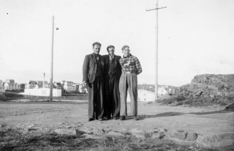 Þetta er í Borgarnesi, myndin er tekin úr Brákarey. Stóra hvíta húsið er gamla mjólkursamlagshús Mjólkursamlags Borgfirðinga, sem Guðjón Samúelsson teiknaði. Borist hefur ábending um að maðurinn lengst til hægri sé Óskar Sigvaldason frá Gilsbakka í Öxarfirði, lengi leigubílstjóri í Reykjavík. / m-stae1-16439 frá Minjasafninu á Akureyri