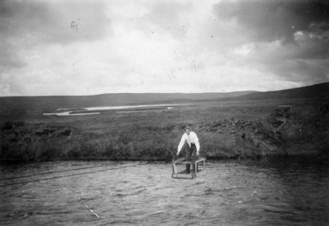 Konan er þarna í kláfi sem eitt sinn var yfir Laxá í Mývatnssveit við bæinn Helluvað. „Kláfurinn er rétt fyrir ofan þar sem gamli brúsapallurinn á Helluvaði var við veginn. Strengirnir eru enn á og stólpar hlaðnir með steinlími,“ sagði Mývetningurinn Benedikt Sigurðarson, fyrrverandi skólastjóri á Akureyri, í athugasemd eftir að myndinni var deilt á Facebook. - / m-stae1-16763 frá Minjasafninu á Akureyri