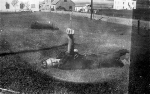Þessi mynd mun tekin á Grenivík og maðurinn í grasinu er sagður heita Gunnar Stefánsson. / m-stae1-16861 frá Minjasafninu á Akureyri