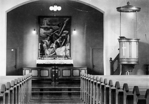 Þetta er Siglufjarðarkirkja. Altaristaflan er óvenjuleg en tilkomumikil, mesta prýði kirkjunnar að margra mati. Hún er máluð af Gunnlaugi Blöndal og var afhjúpuð 5. september 1937. - / m-stae1-17014 frá Minjasafninu á Akureyri