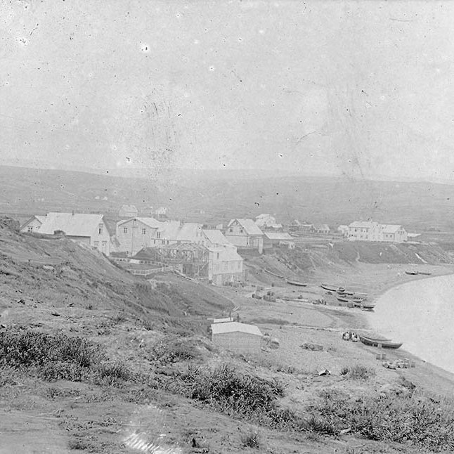 Þessi mynd er frá Húsavík. Margir lesendur voru sammála um það og bent var á að myndin væri tekin fyrir 1907 því ekki sé búið að byggja kirkjuna. Í pósti frá einum segir: Húsaþyrpingin í forgrunni eru KÞ húsin og stóru húsin hægra megin eru sennilega Guðjonhsen húsin, verslun-vöruhús-heimili.
Gilið rétt sunnan við þau hús er Búðarárgilið, þar sem Búðaráin rennur til sjávar, en hún á upptök í Botnsvatni sem er skammt fyrir ofan Húsavík, uppundir Reykjaheiði. / m-stae-5-0003b frá Minjasafninu á Akureyri
