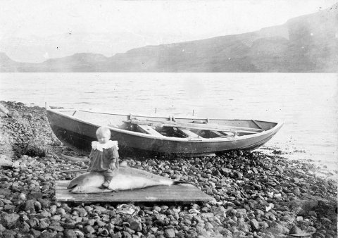 Þetta er á Eskifirði, eins og margir lesendur töldu. Ábending barst um að myndin hefði birst á Facebook síðunni Lemúrinn árið 2016. Á síðu Lemúrsins segir: Eins árs gamall drengur á hnísubaki á Eskifirði 1906. Mynd: Ingimundur Sveinsson. Þar er myndin merkt Þjóðminjasafni Íslands og á hana er stimplað: Ingimundur Sveinsson sönglistarmaður. 
Einn lesenda akureyri.net taldi sig eiga að vita nafn barnsins á myndinni en mundi það ekki í svipinn. Spennandi verður að sjá hvort það rifjast upp fyrir honum. - / mstae-5-2040 frá Minjasafninu á Akureyri