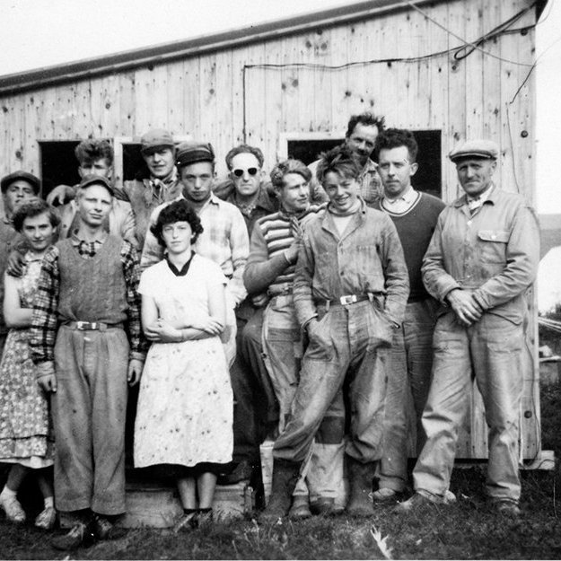 Steinunn Björg Gunnarsdóttir sendi eftirfarandi upplýsingar: „Pabbi og mamma telja að myndin sé tekin í Vatnsfirði í Vestur-Barðastrandarsýslu. Konurnar eru Laufey Böðvarsdóttir móðursystir mín frá Tungumúla (lengst til vinstri) og Björg Bjarnadóttir frá Rauðsdal, fyrir aftan hana stendur Hafliði Árnason frá Flatey. Annar frá [hægri] í fremstu röð (með hendur í vösum) er Samúel Bjarnason frá Rauðsdal. Fyrir aftan Samúel er Sigurjón Árnason frá Flatey (dökk peysa og hvít skyrta). Maðurinn í röndóttu peysunni er Einar Sigurbrandsson frá Grænhól. Væri gaman að sjá ef það eru til fleiri myndir frá þessum vinnuflokki.“ - / m-stae1-17355 frá Minjasafninu á Akureyri
