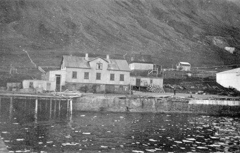 Þetta er húsið Bakki á Siglufirði sem Pétur J. Thorsteinsson á Bíldudal byggði snemma á síðustu öld, líkast til 1917. Steinsnar frá var reist söltunarstöð, sem einnig var kölluð Bakki. Það mun vera hvíta húsið sem sést í lengst til hægri á þessari mynd; akureyri.net fékk sendar upplýsingar um að Pétur hefði einnig byggt söltunarstöðina á árunum 1916-1919 en heimildum ber ekki saman. Á vef Síldarminjasafns Íslands á Siglufirði segir í grein eftir Benedikt Sigurðsson: „Eitt af fyrirtækjum Óskars Halldórssonar, Hrogn og lýsi h.f., byggði íshúsið á söltunarlóð sinni í Bakka 1925.“ – Óskar, útgerðarmaður og síltarsaltandi (fyrirmyndin að síldargrósseranum Íslandsbersa í Guðsgjafaþulu Halldórs Laxness) leigði húsið á þessari mynd um tíma fyrir starfsemi fyrirtækis síns, skv. grein Benedikts, en síðar voru gerðar  fjórar íbúðir í húsinu og búið í því allt til ársins 1982. Slökkvilið Siglufjarðar fékk þá húsið til æfinga og var það brennt til kaldra kola á æfingu árið 1983. - / m-stae1-17597 frá Minjasafninu á Akureyri
