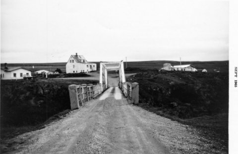 Gamla brúin á Skjálfandafljóti við Fosshól. Verslun KSÞ, Kaupfélags Svalbarðseyrar, til vinstri og Fosshólsbærinn fyrir miðju en þar var lengi vel símstöð.