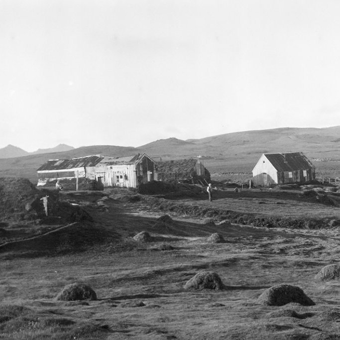 Ólafur Jónsson, ráðunautur og rithöfundur,  tók þessa mynd. Þetta eru leifar Krýsuvíkurbæjarins og Krýsuvíkurkirkja um 1950. Hæsti tindur Sveifluhálsins að handan er Miðdegishnúkur (Hádegishnúkur). Á miðri mynd, milli húsanna og kirkjunnar sést til Stóra-Nýjabæjar. Ofan bæjarins er Tindhóll. Bæirnir voru jafnaðir við jörðu með jarðýtu með samþykki Þjóðminjavarðar um 1958. Kirkja, sem fékk að standa áfram, hafði verið aflögð sem slík og notuð sem íbúðarhúsnæði þegar þessi mynd var tekin. - Minjasafnið á Akureyri / a1-04087-03   frá Minjasafninu á Akureyri