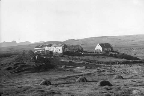 Ólafur Jónsson, ráðunautur og rithöfundur,  tók þessa mynd. Þetta eru leifar Krýsuvíkurbæjarins og Krýsuvíkurkirkja um 1950. Hæsti tindur Sveifluhálsins að handan er Miðdegishnúkur (Hádegishnúkur). Á miðri mynd, milli húsanna og kirkjunnar sést til Stóra-Nýjabæjar. Ofan bæjarins er Tindhóll. Bæirnir voru jafnaðir við jörðu með jarðýtu með samþykki Þjóðminjavarðar um 1958. Kirkja, sem fékk að standa áfram, hafði verið aflögð sem slík og notuð sem íbúðarhúsnæði þegar þessi mynd var tekin. - Minjasafnið á Akureyri / a1-04087-03   frá Minjasafninu á Akureyri