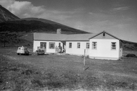 Ólafur Jónsson, ráðunautur og rithöfundur,  tók þessa mynd á jörðinni Sellandi í Fnjóskadal, sem Sigurður O. Björnsson prentsmiðjustjóri keypti og stundaði þar gríðarlega umfangsmikla skógrækt. Sigurður og síðari eiginkona hans, Kristín Bjarnadóttir, eru vinstra megin á stéttinni en ekki er vitað hverjir mennirnir tveir eru. Jeppinn á myndinni var í eigu Sigurðar og Kristínar; strangt til tekið var jeppabifreiðin raunar í eigu Ingibjargar dóttur þeirra, sem vann bílinn í happdrætti þegar hún var sjö ára gömul!