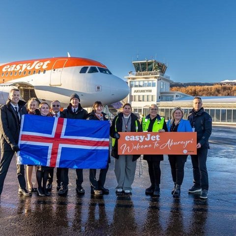 Áhöfn fyrstu easyJet vélarinnar með íslenska fánann. Á easyJet skiltinu halda, frá vinstri, Rosanna Medina, tengiliður Easy Jet við Akureyrarflugvöll, Hjördís Þórhallsdóttir flugvallarstjóri á Akureyrarflugvelli, Arnheiður Jóhannsdóttir framkvæmdastjóri M