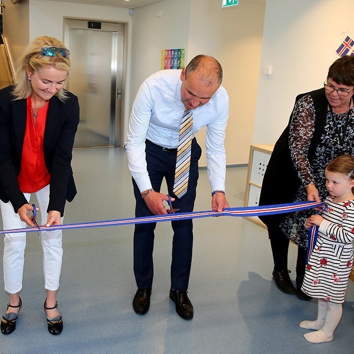 Guðni Th. Jóhannesson forseti Íslands og Halla Björk Reynisdóttir forseti bæjarstjórnar Akureyrar vígðu leikskólann Klappir formlega með því að klippa á borða. Nemendurnir Helgi Þór Einarsson og Fríða Nótt Einarsdóttir hjálpuðu til með því að halda í borðinn. Ljósmynd: Þorgeir Baldursson