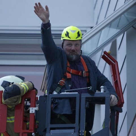 Ég er hólpinn! Eyjólfur rektor veifar til nemenda og starfsfólks háskólans, sem komust út heilu og höldnu, eftir að honum var „bjargað“ af skrifstofu sinni á 4. hæð.